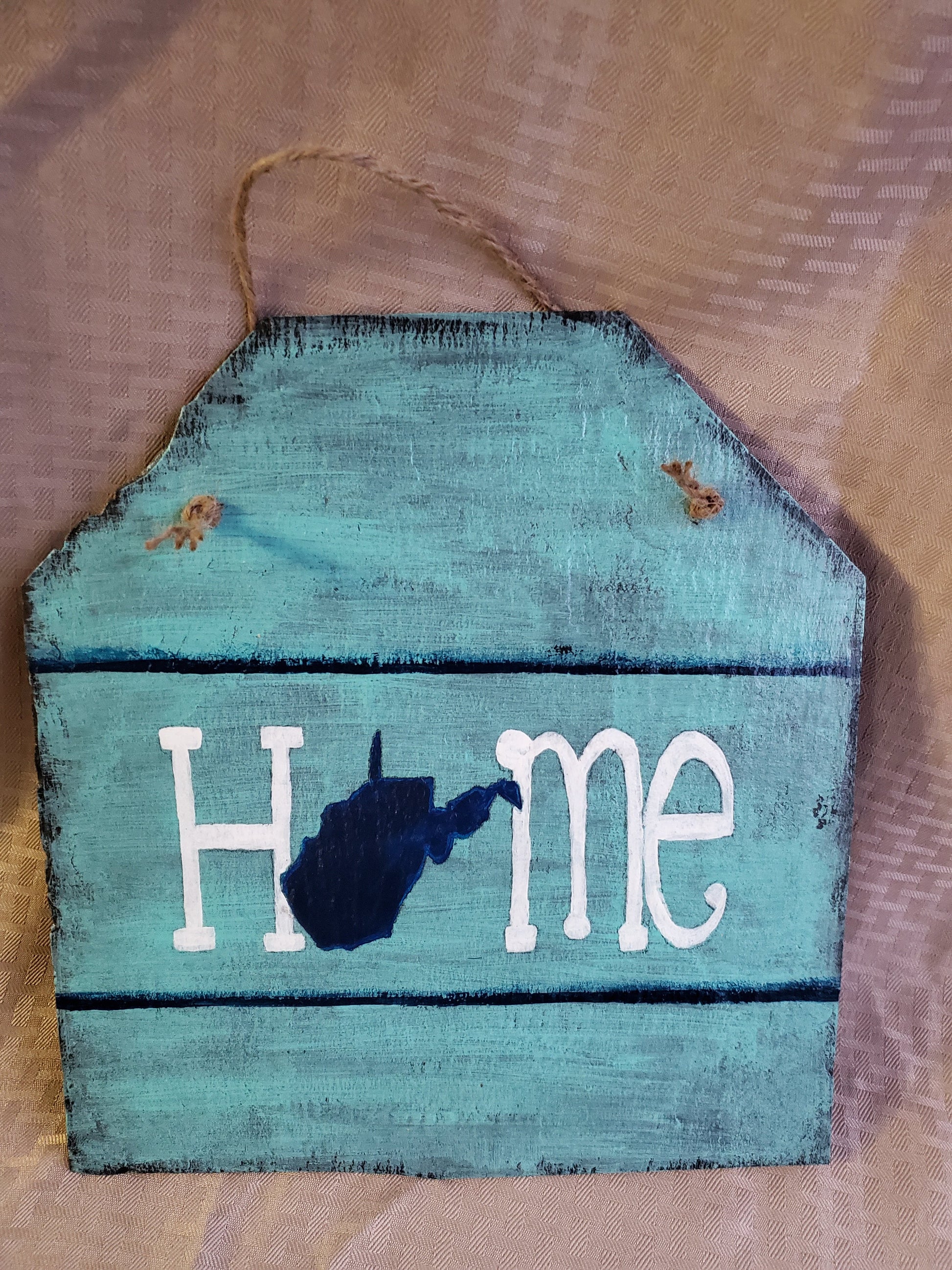 "HOME" Approximately 12"x12" hand-painted slate with West Virginia state outline, rustic style, light blue background, navy blue state shape in place of the "o"