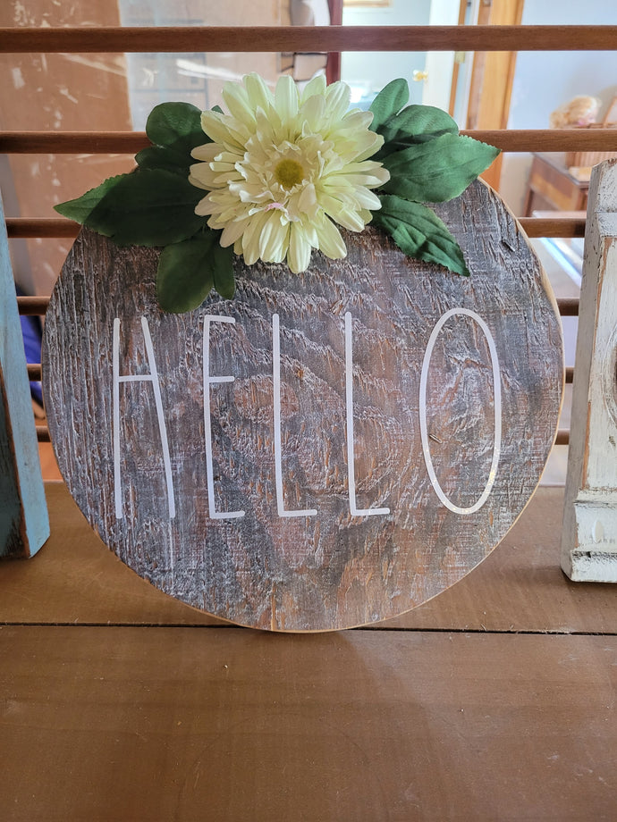 Round hello sign, stained, white letters, yellow flower with leaves