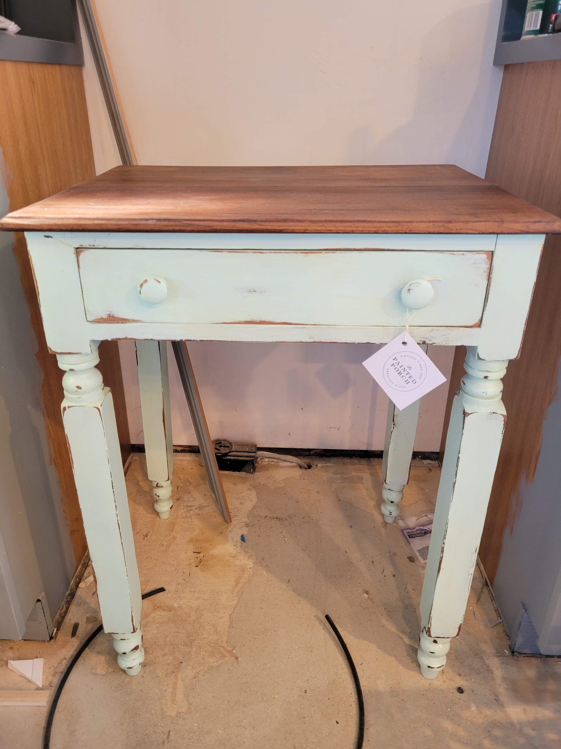 Small, antiqued, mint green end table with one drawer with natural wood top