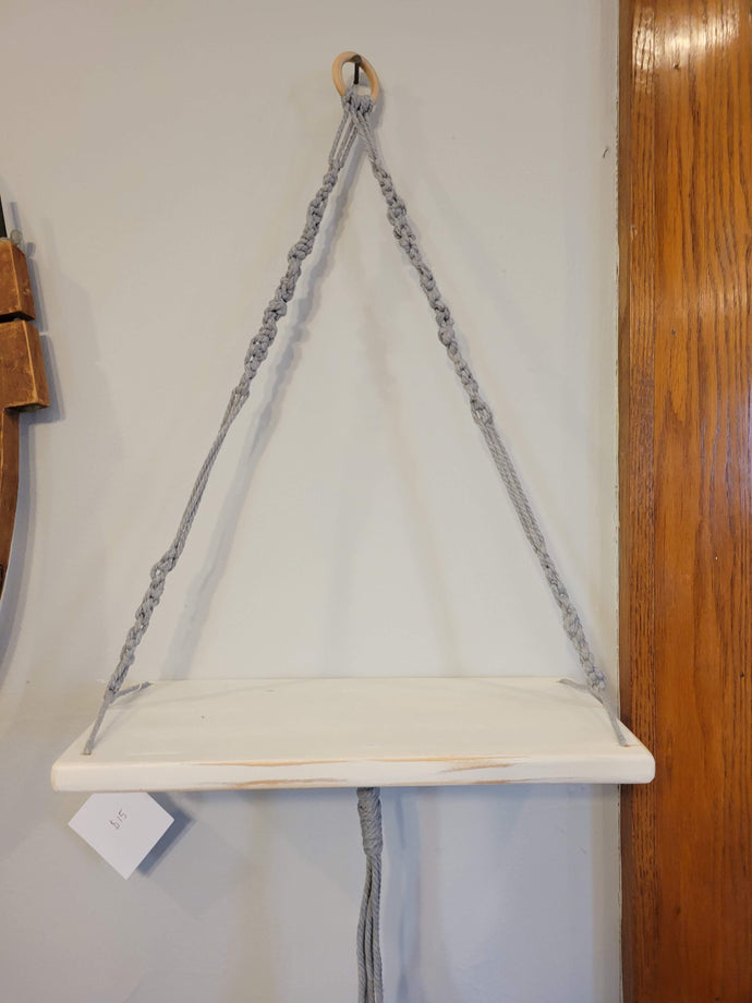 White wooden hanging shelf with gray macramé rope.