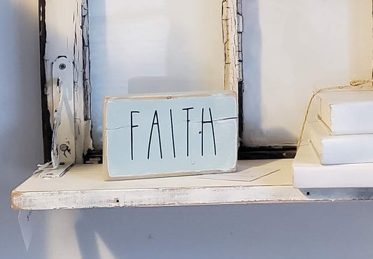 Wooden block sign painted light blue and sanded. Black vinyl letters "Faith." Approximately 2" x 4" x 6"