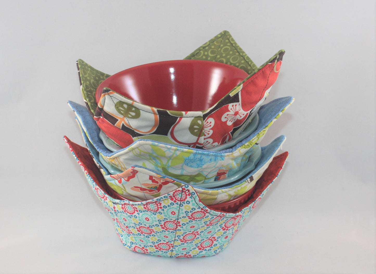 Variety of colors and patterns, these handmade bowl sleeves will protect your hands from the heat while also adding a pretty pop of color to your kitchen. Bowl included! Each sleeve is unique. Choose between a red or blue bowl.