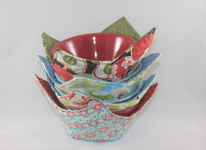 Variety of colors and patterns, these handmade bowl sleeves will protect your hands from the heat while also adding a pretty pop of color to your kitchen. Bowl included! Each sleeve is unique. Choose between a red or blue bowl.