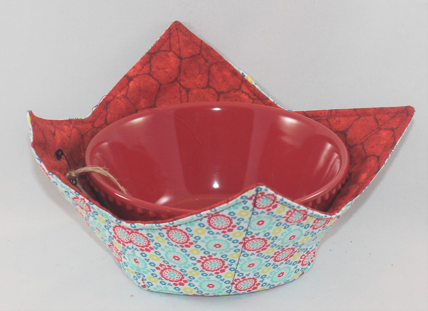 Variety of colors and patterns, these handmade bowl sleeves will protect your hands from the heat while also adding a pretty pop of color to your kitchen. Bowl included! Each sleeve is unique. Choose between a red or blue bowl.