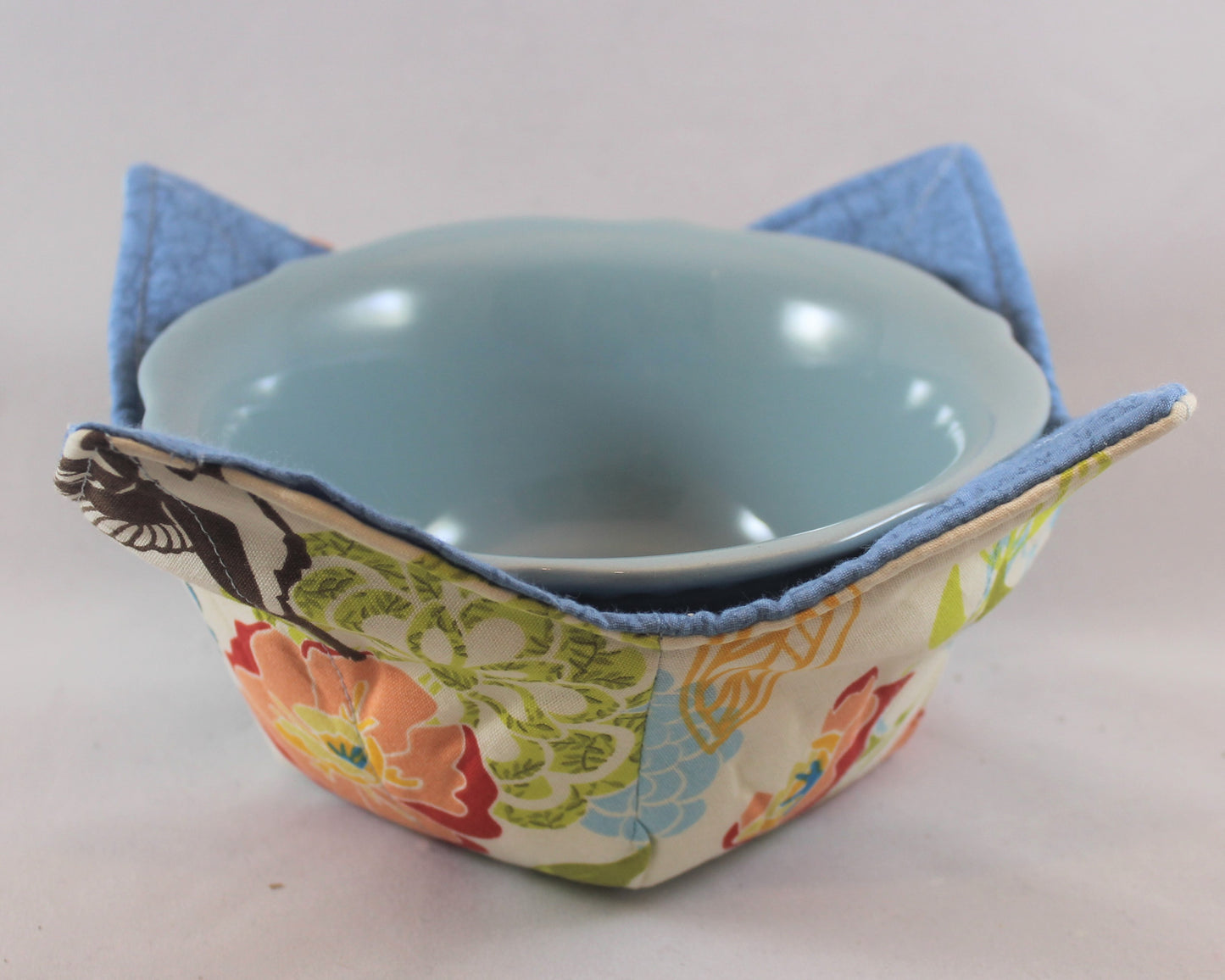 Variety of colors and patterns, these handmade bowl sleeves will protect your hands from the heat while also adding a pretty pop of color to your kitchen. Bowl included! Each sleeve is unique. Choose between a red or blue bowl.