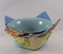 Load image into Gallery viewer, Variety of colors and patterns, these handmade bowl sleeves will protect your hands from the heat while also adding a pretty pop of color to your kitchen. Bowl included! Each sleeve is unique. Choose between a red or blue bowl.
