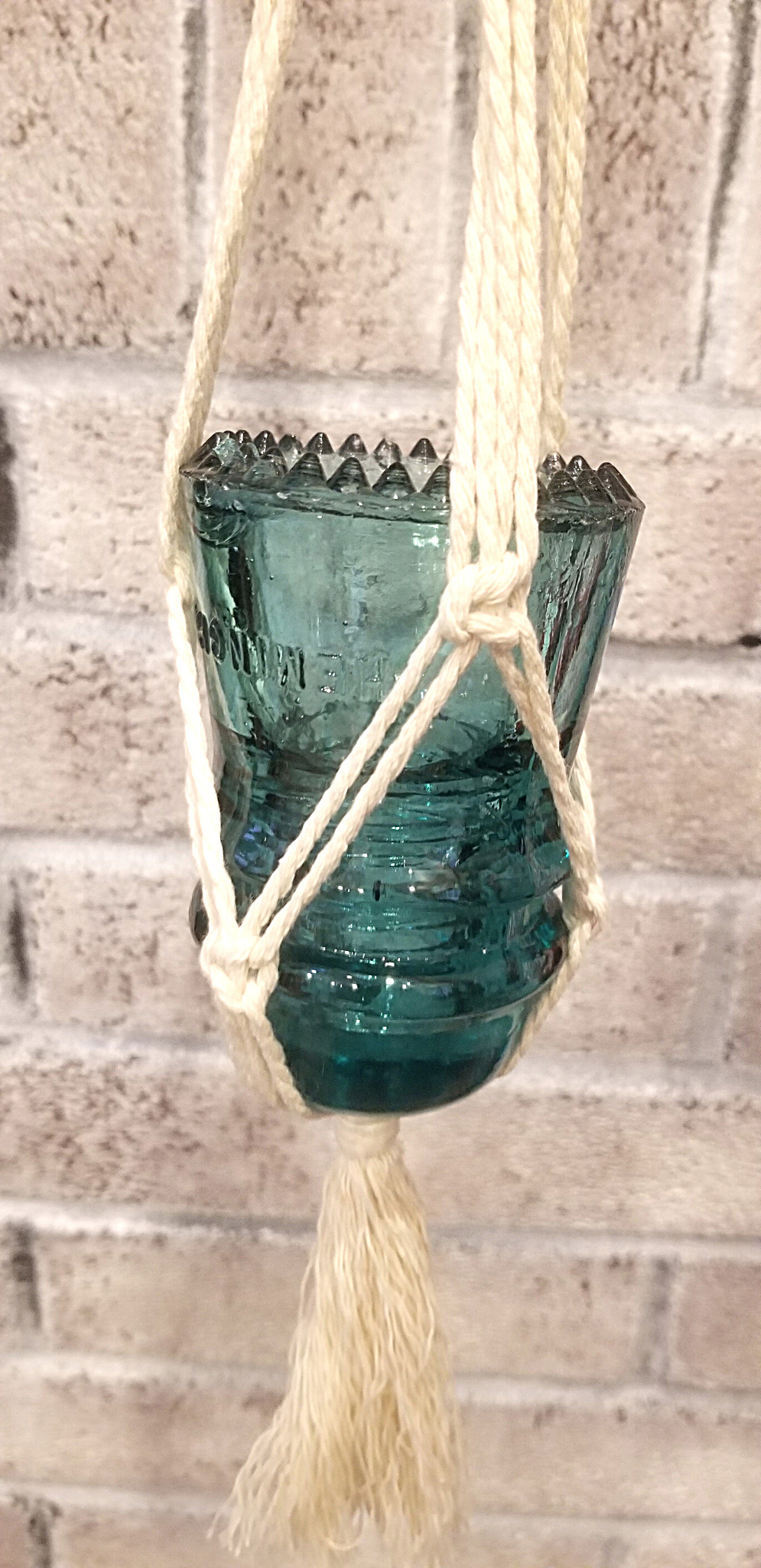 Macramé hanger with antique blue glass insulator.