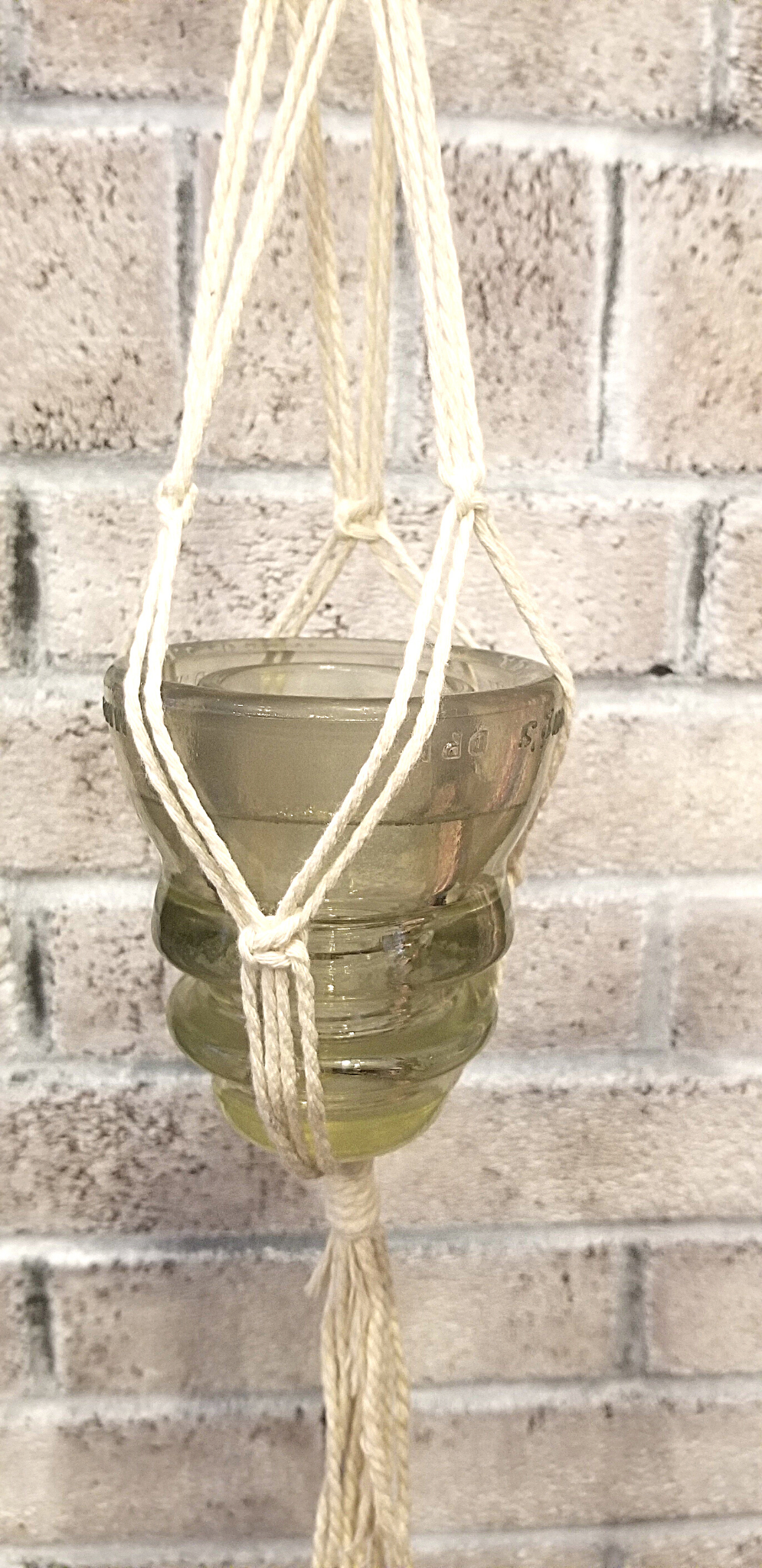 Macramé hanger with antique glass insulator.