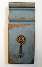 Load image into Gallery viewer, This gorgeous plinth was recovered from an old farm house. It has been painted blue and sanded. The interesting hammered metal spiral hook adds another dimension to this wall decor. 
