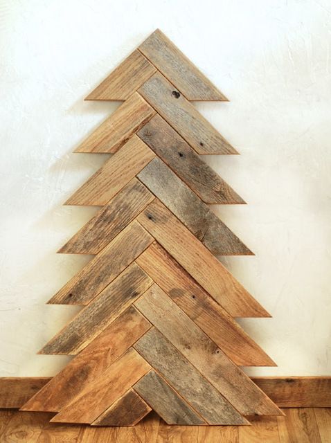 Build a Christmas tree with pallet wood. Angle cut pallet wood arranged in the shape of a pine tree. DIY rustic Christmas décor.