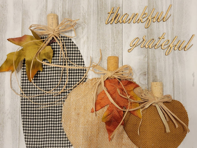 Design your own pumpkin patch with different fabrics, wine corks, and raffia. Customize your size with your own fall phrase: thankful, hello fall, etc.