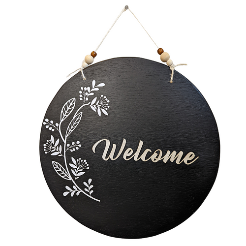 This black wooden Welcome sign has bohemian vibes with the three dimensional paper flower detail and multi-colored wooden beads. The 